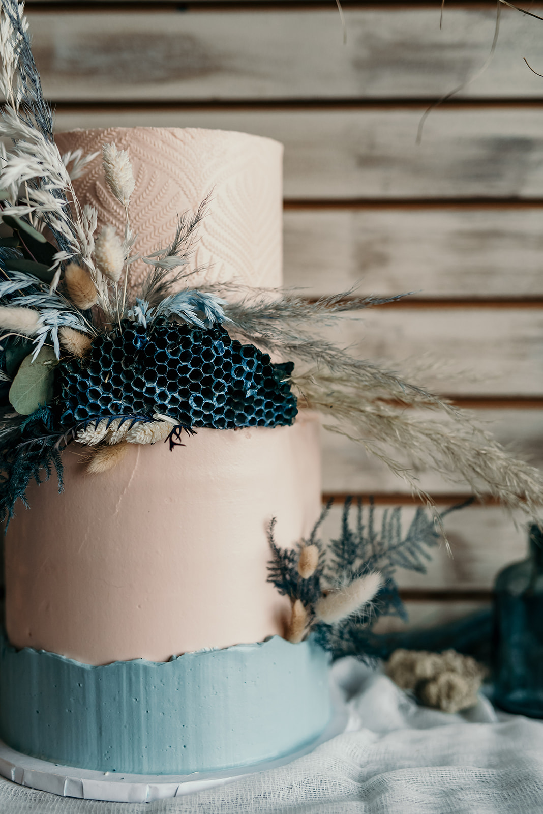 Bohemian wedding cake with deep blue and teal accents and a honeycomb spray painted blue