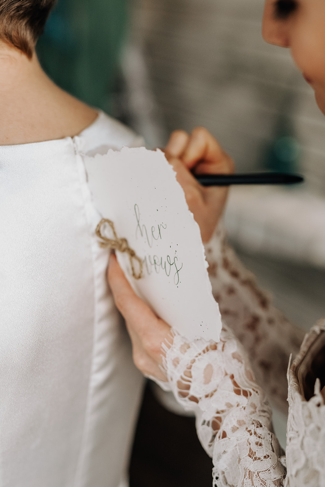 Brides take turns writing out their wedding vows on each other's backs