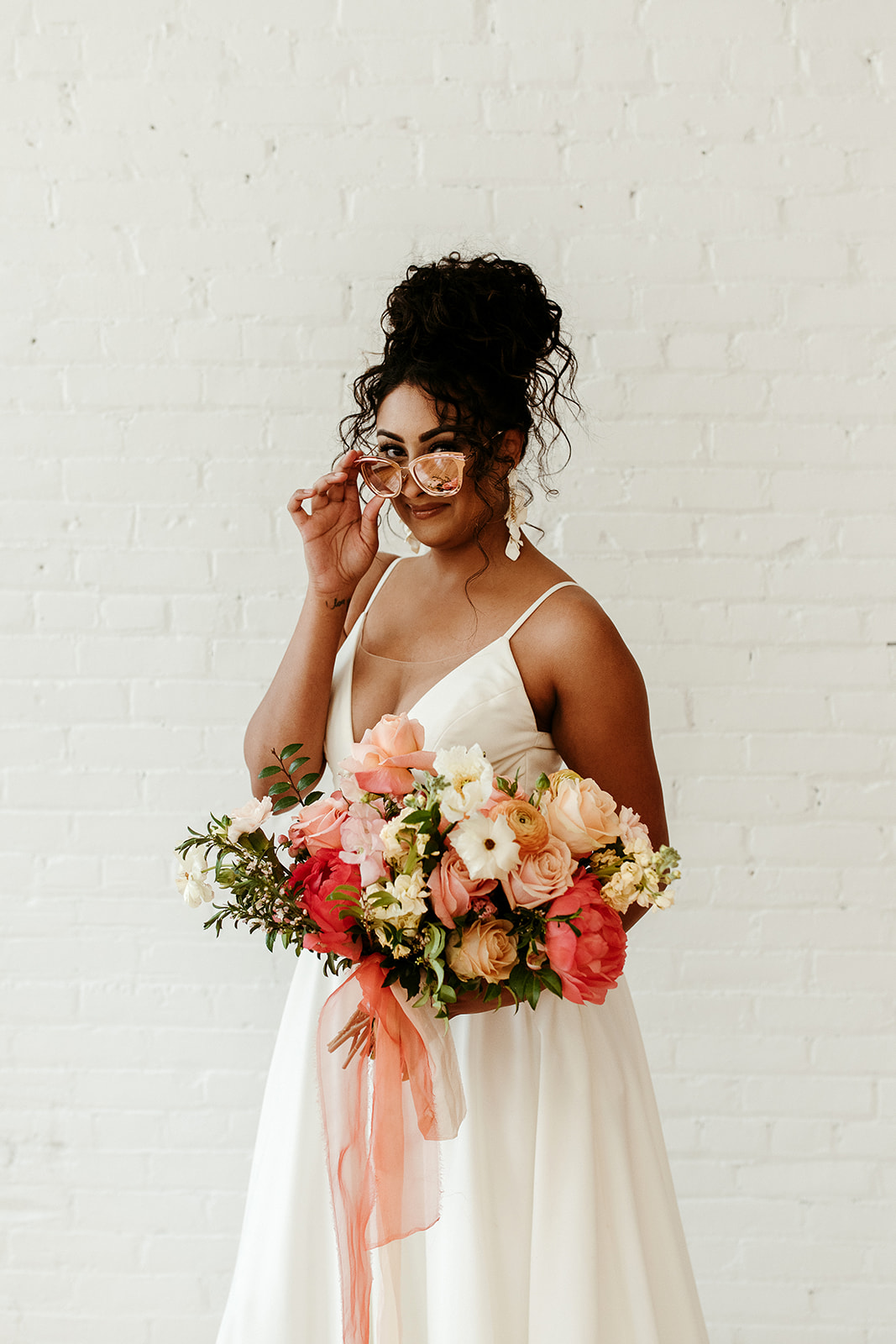 Bold bridal updo for the curly haired bride with bold citrus floral details