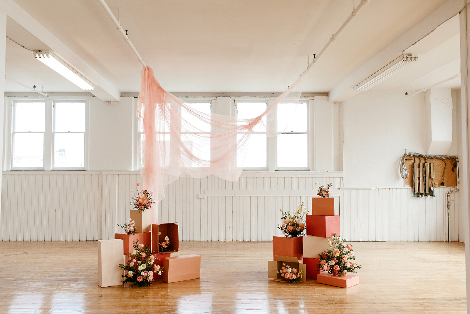 Unique DIY Ceremony design with painted cardboard boxes, citrus colour palette and a hanging fabric backdrop