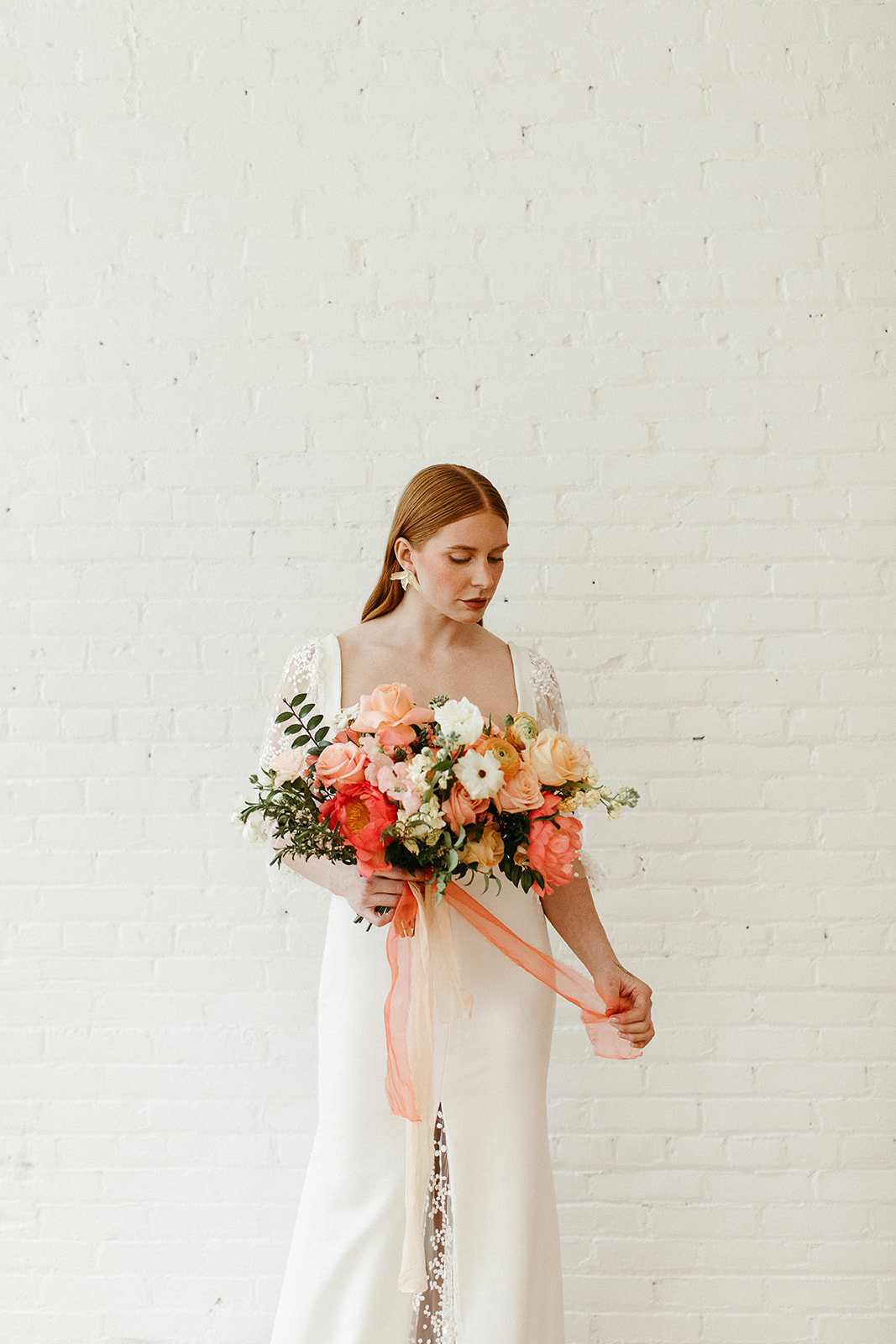 Sleek bridal style in a Delica Bride gown with citrus florals