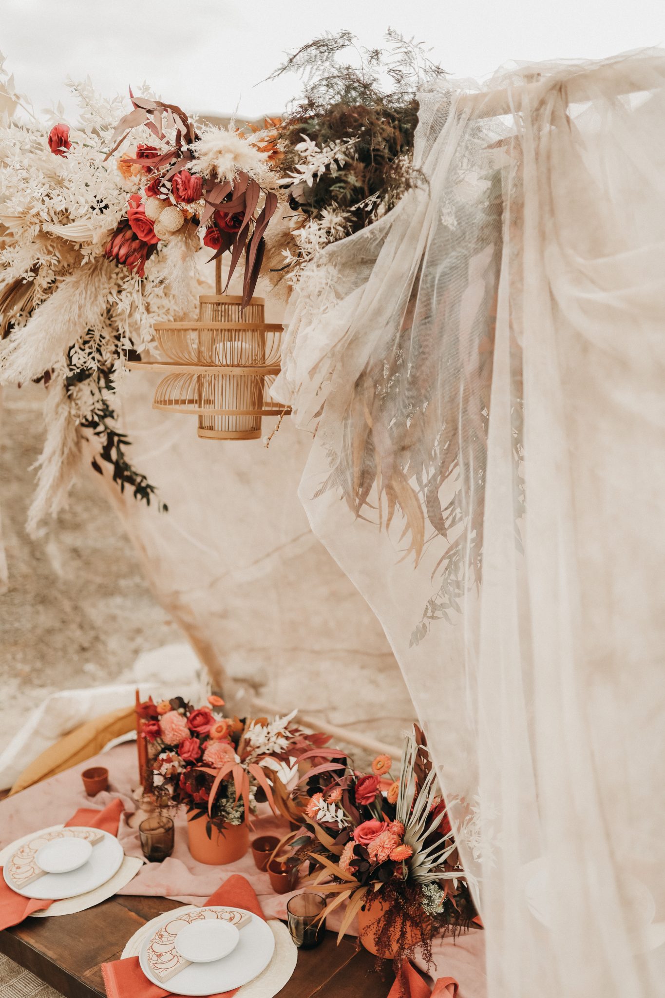 Moroccan elopement inspiration with a linen tent, wicker chandelier and boho terracotta flowers