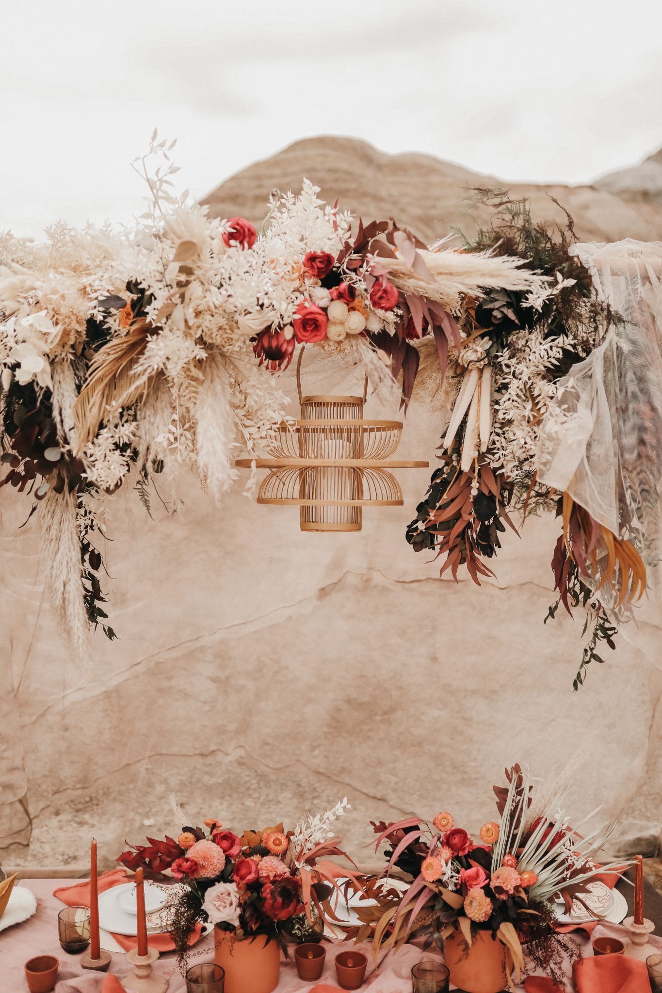 Decor for a Moroccan inspired elopement with boho florals, a wicker chandelier and linen tent