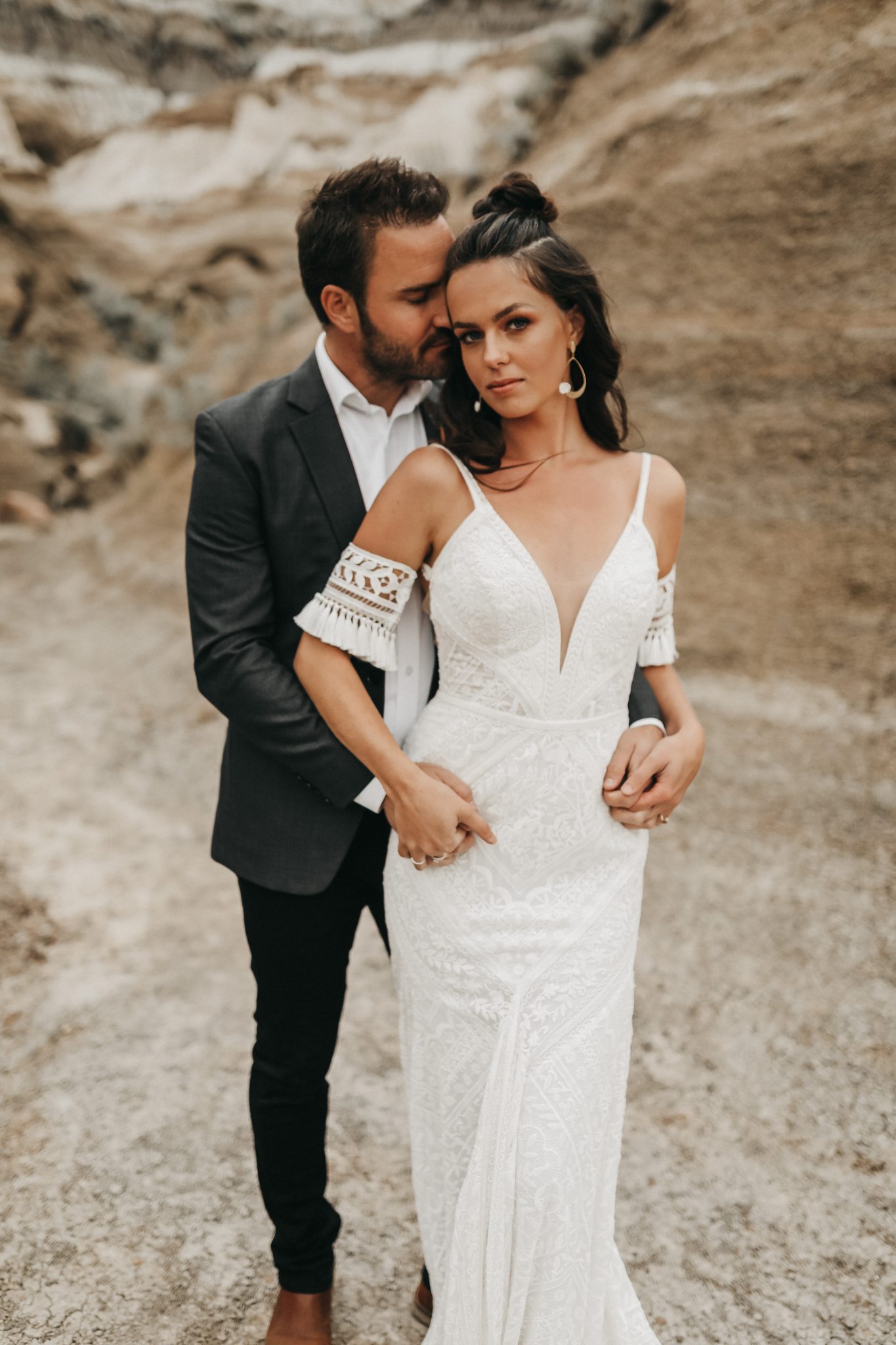 Boho bride poses with her groom for this Moroccan Inspired Elopement featuring lace bridal cuffs