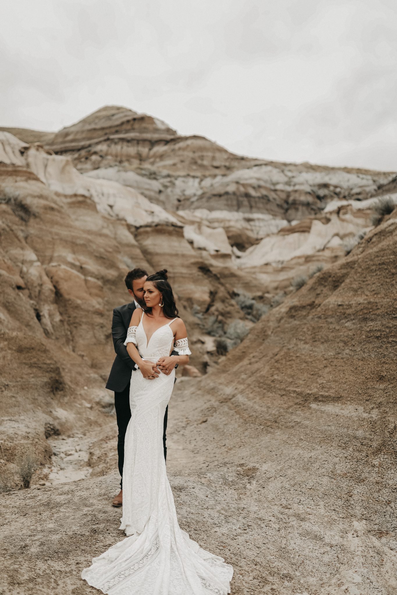 Bride and groom pose amongst the sand hills of Drumheller Alberta for a moroccan inspired elopement