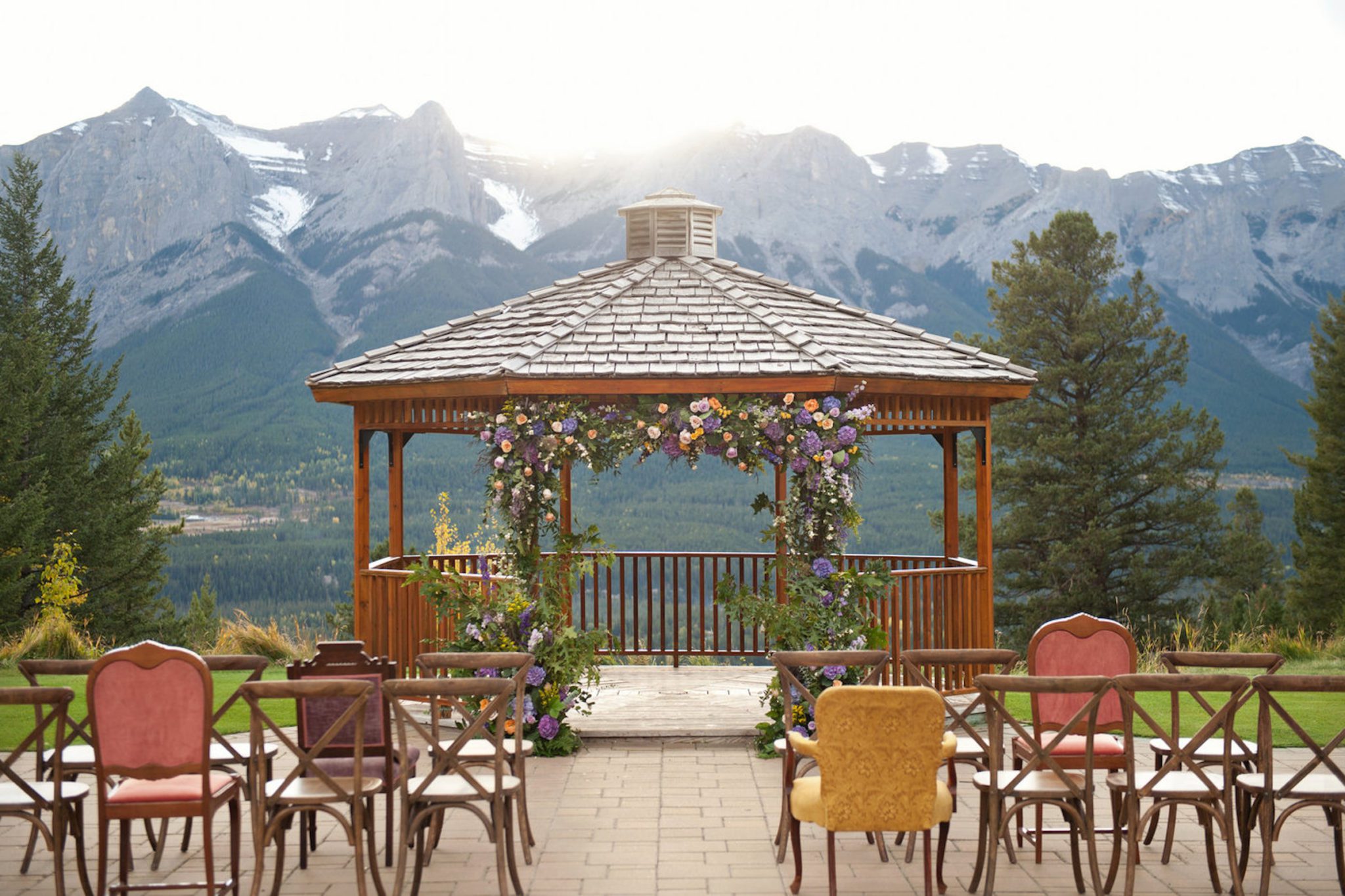 Vintage and rustic ceremony design at with purple flowers and greenery at Silvertip Resort in Canmore Alberta