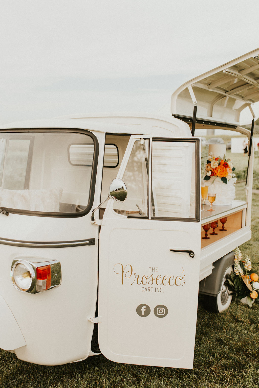 Prosecco mobile bar cart decorated with tangerine accents for a wedding editorial at The Gathered, a wedding venue near Calgary Alberta