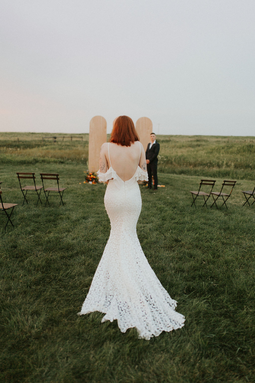 Bride walks down the aisle in a dreamy backless wedding dress with ruffled sleeves from Lovenote Bride