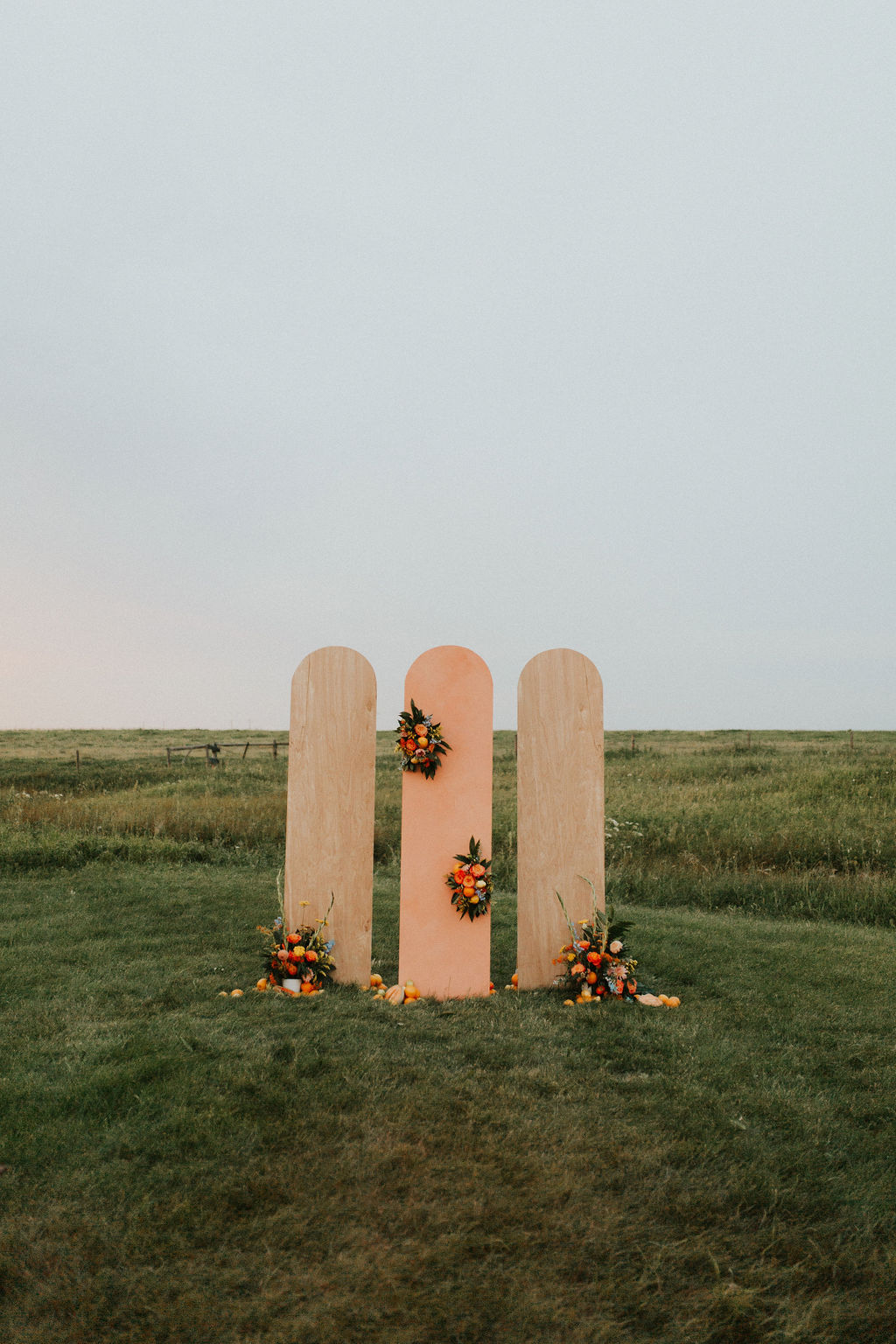 Wooden panel ceremony backdrops with floral installations for a tangerine inspired wedding 