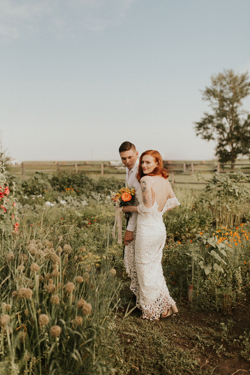 Bride and groom walk together through a flower garden at The Gathered, a wedding venue near Calgary Alberta