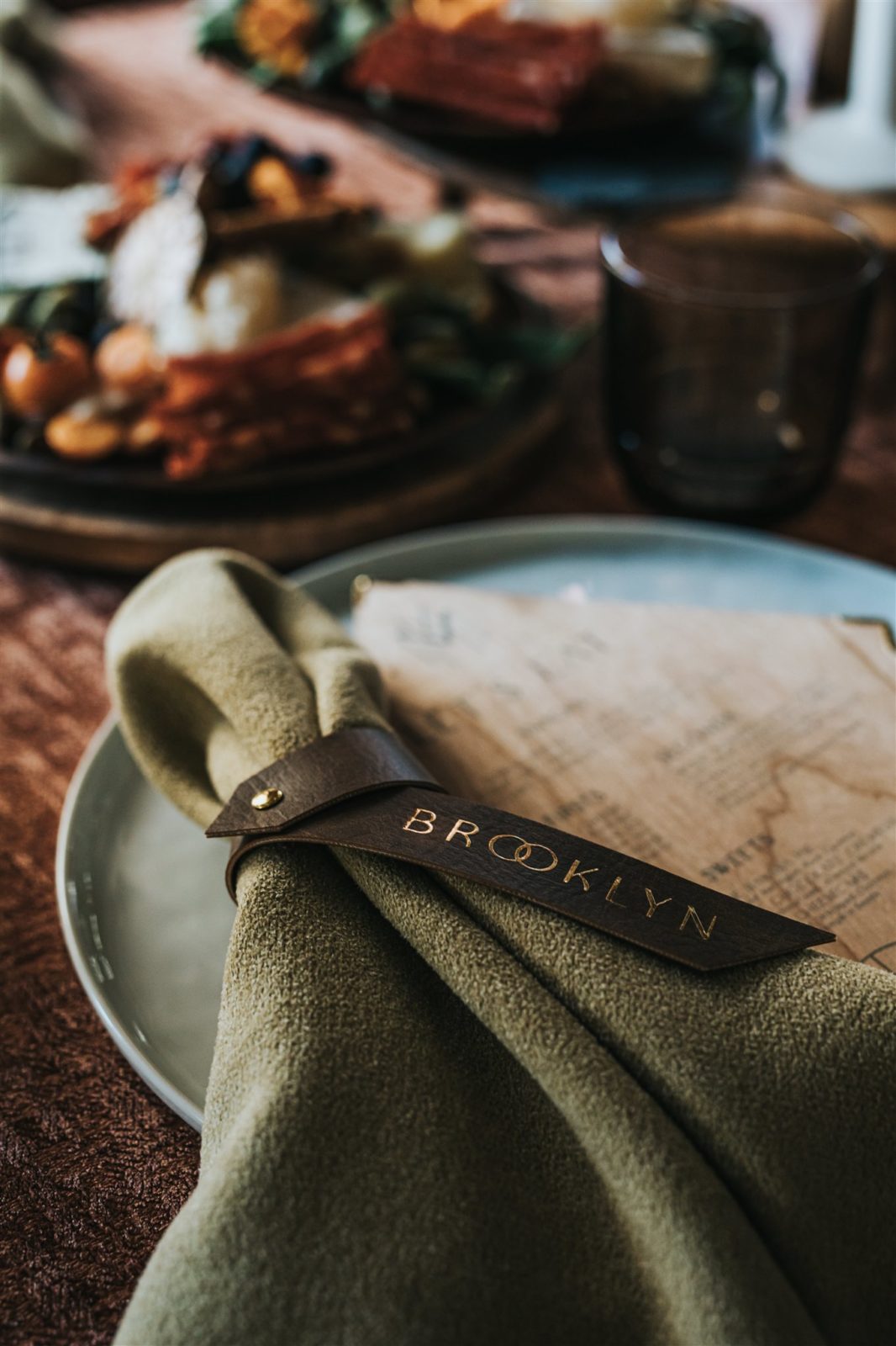 Sage napkins tied with a leather name place card for a fall inspired wedding