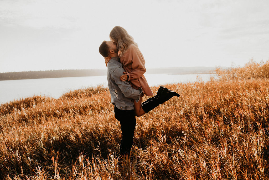 Dreamy engagement session outfit inspiration for a lakeside sunset engagement session with a blush dress and denim jacket