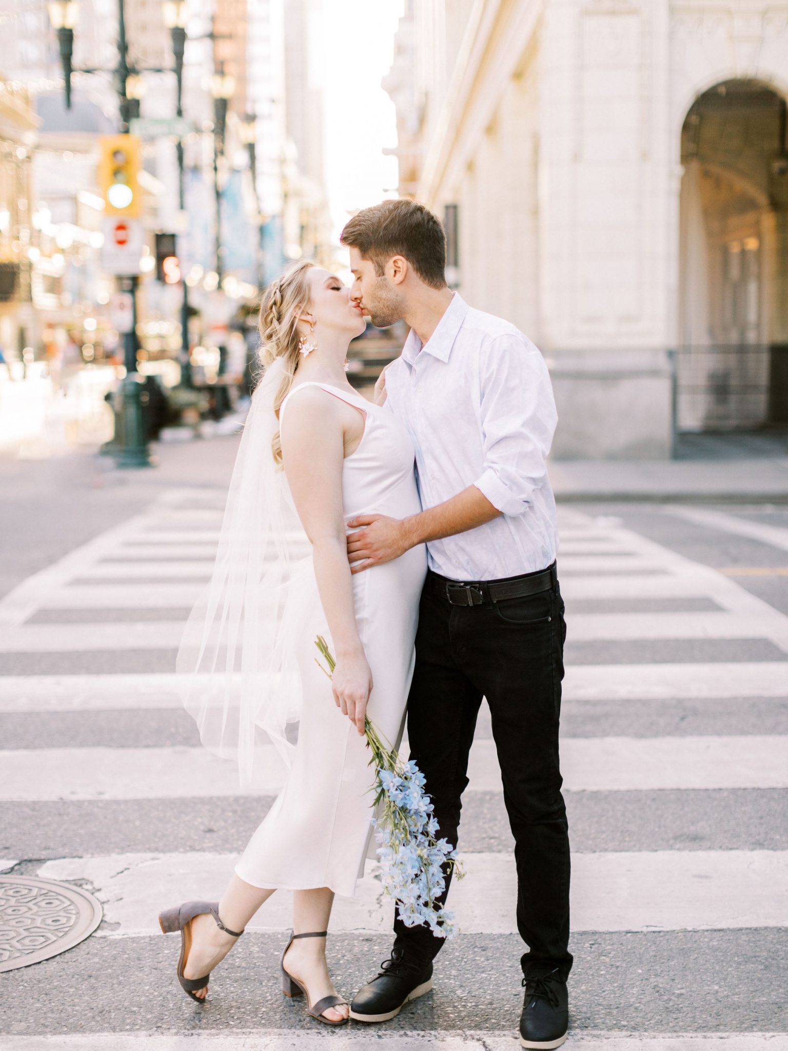 Bride and groom share a kiss in the heart of downtown Calgary for this modern monochromatic wedding