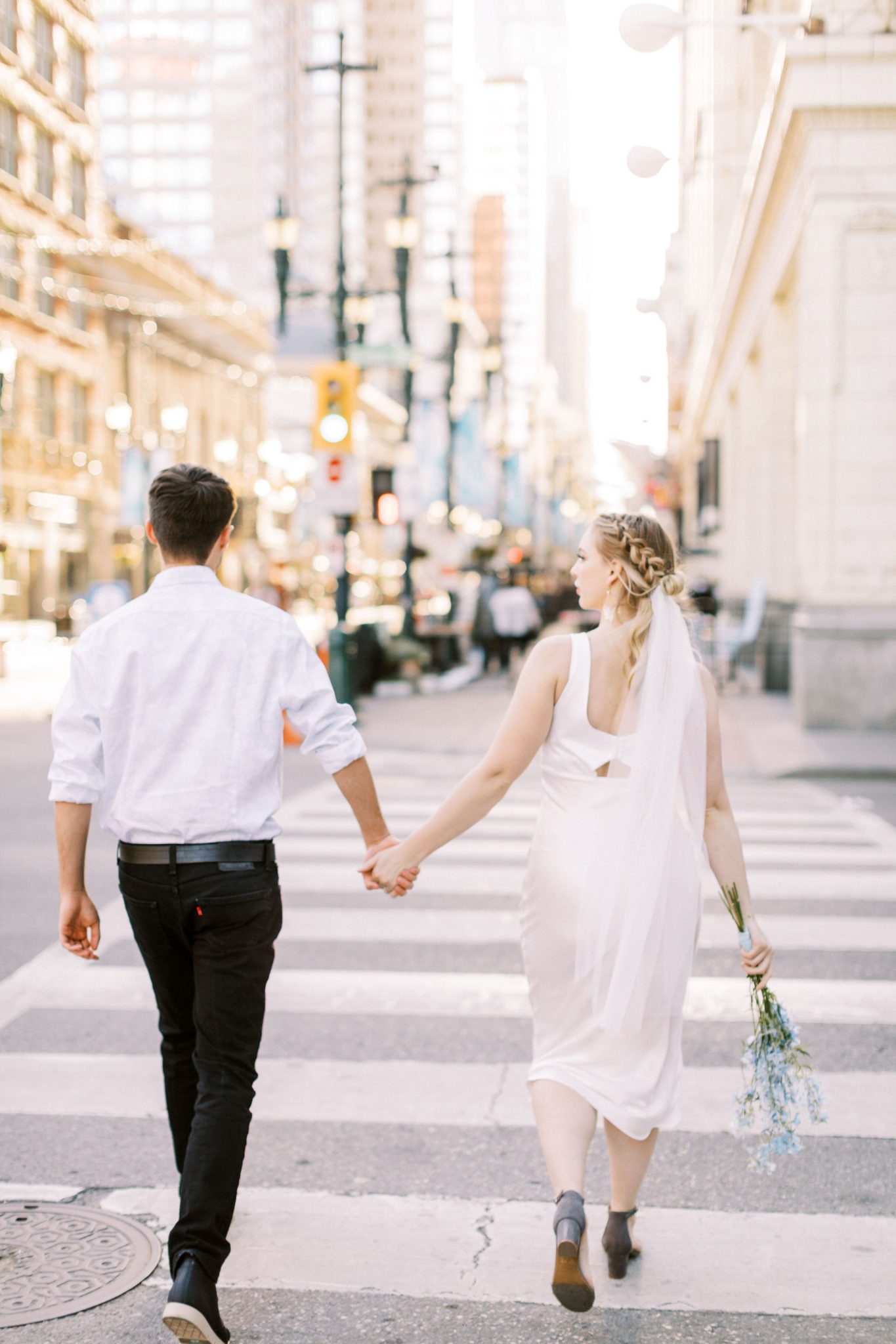 Modern bride and groom walk hand in hand through downtown Calgary for this elopement inspiration