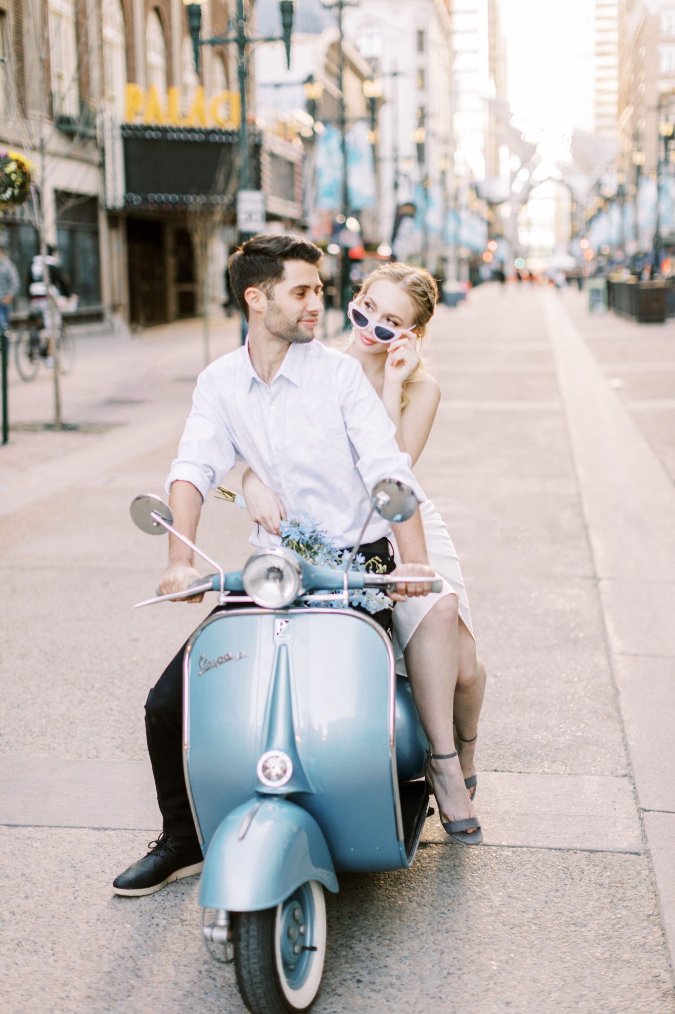 Modern bride and groom ride a blue vespa through the streets of Calgary for this downtown elopement inspiration