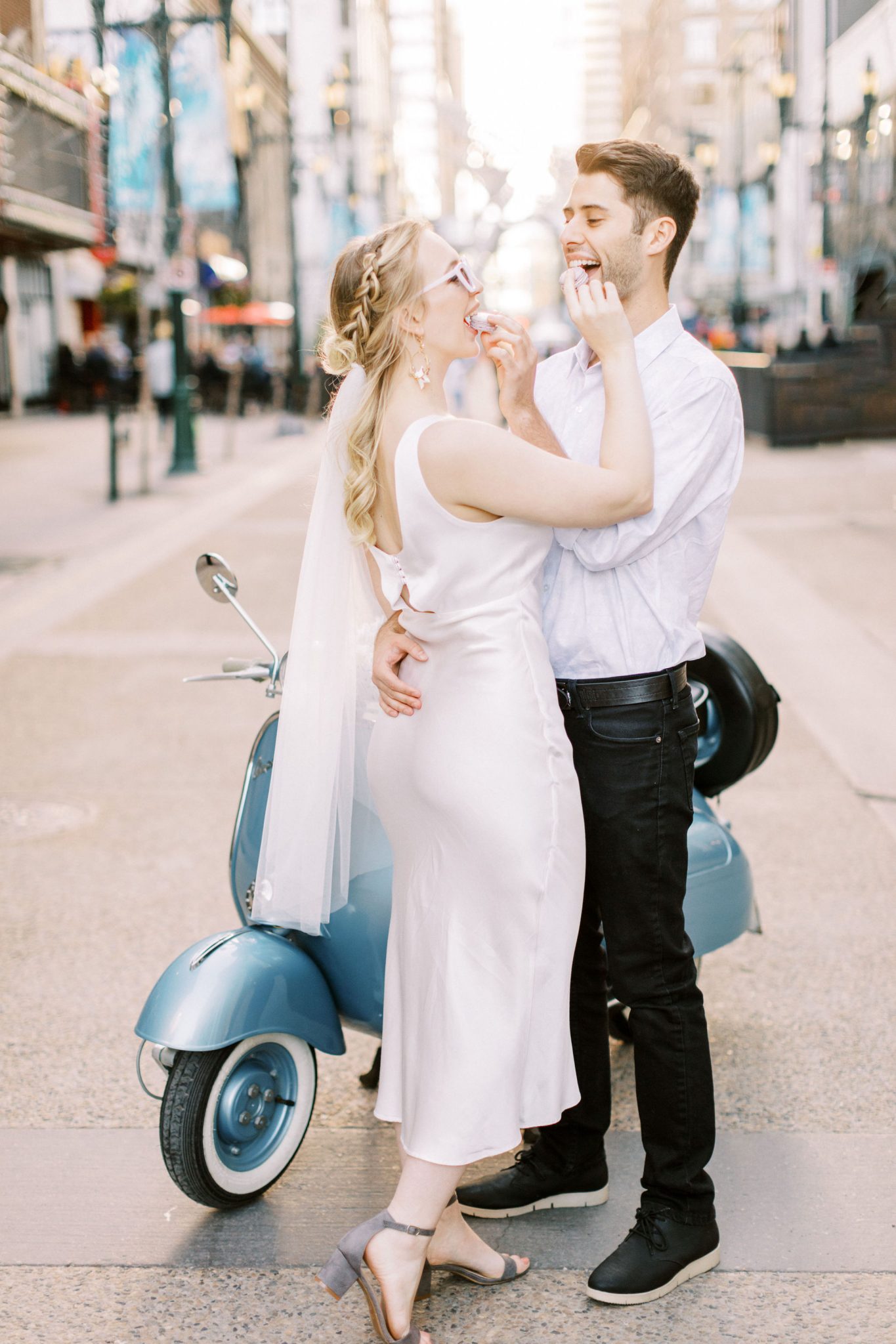 Playful bride and groom share macarons on Stephen Avenue for this modern downtown elopement inspiration