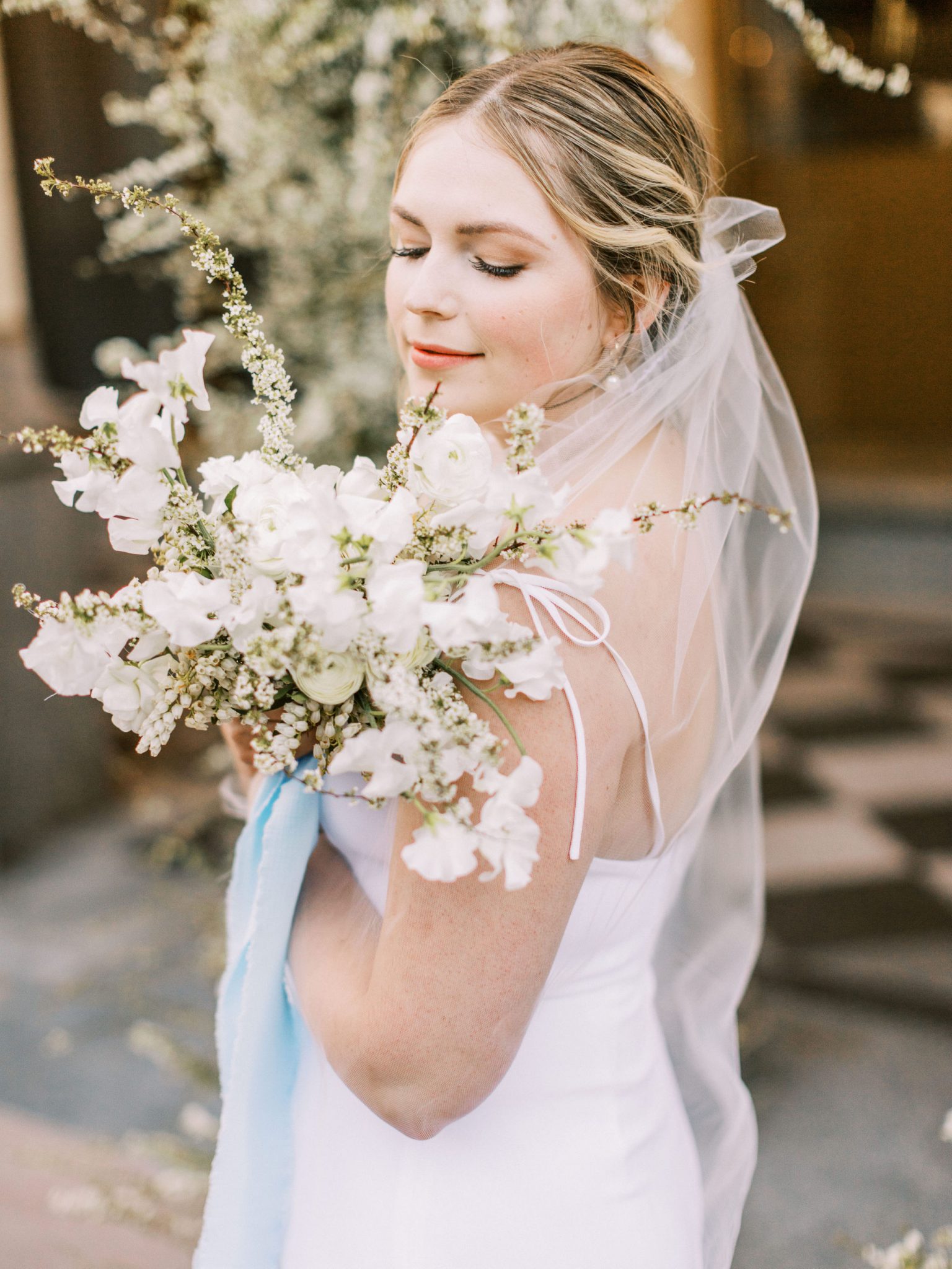 Monochromatic white and green bridal bouquet with a blue silk ribbon