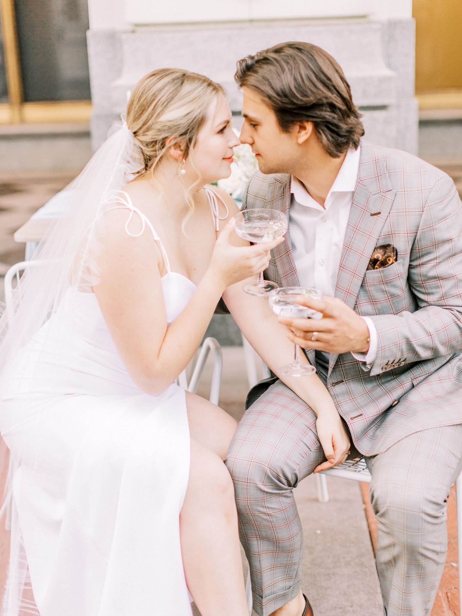 Bride and groom share a glass of champagne outside the Hudson for their downtown elopement