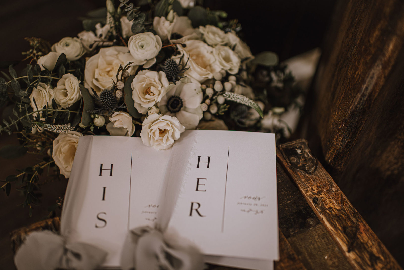 His and her vow booklets with a monochromatic bouquet