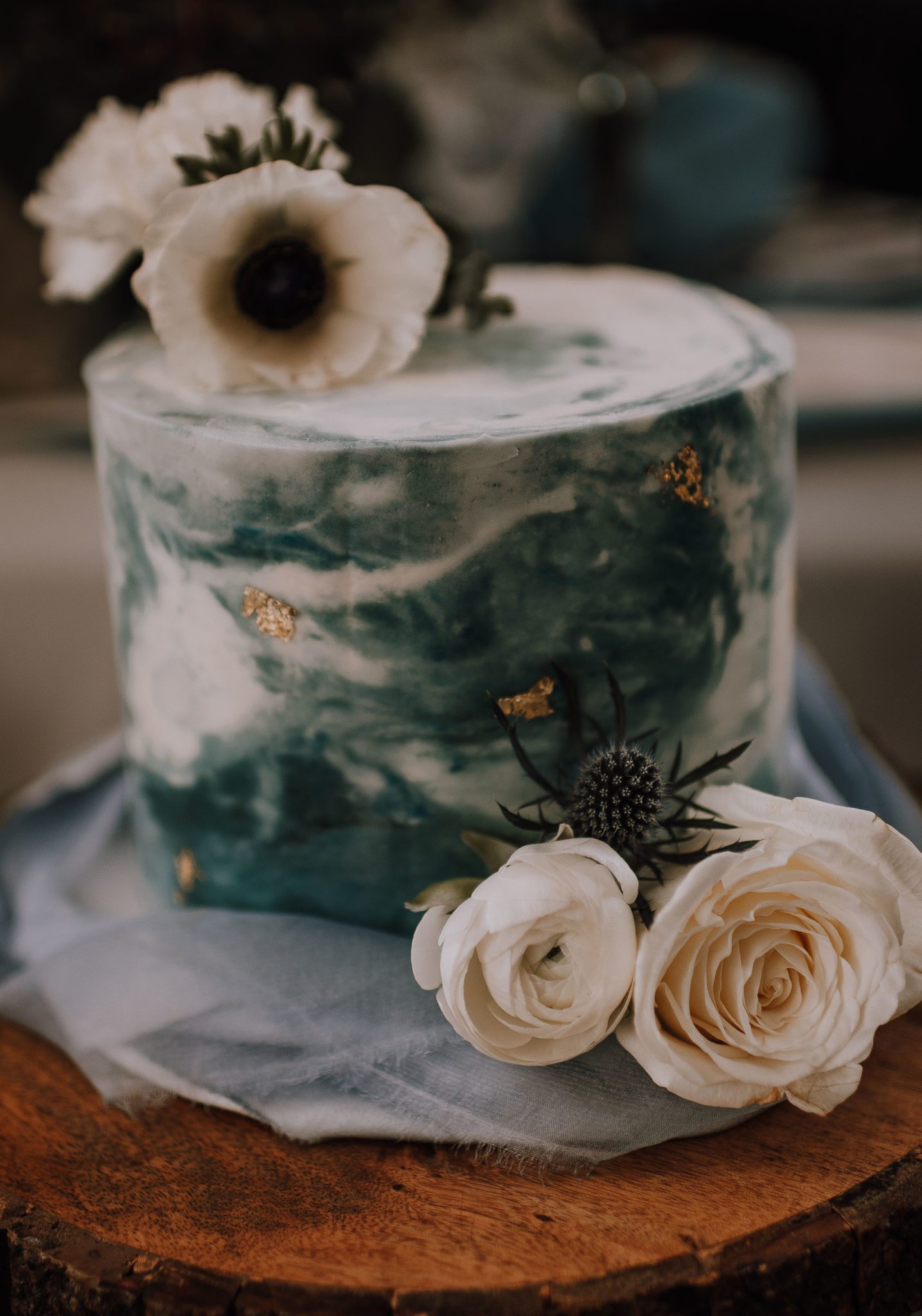 Single tiered marbled cake with blue and gold accents