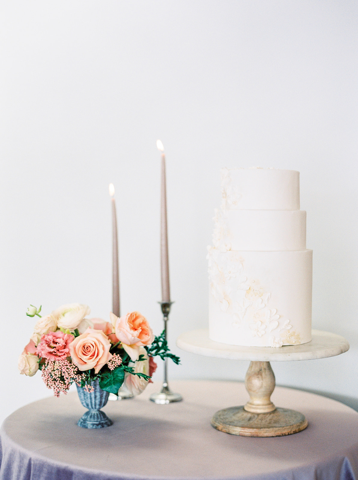 Show-stopping monochromatic white wedding cake with floral details