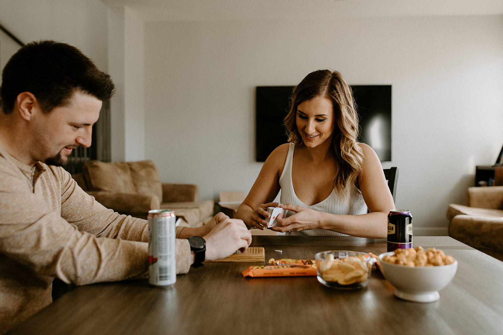 Couple enjoys beers, snacks and a game of crib during this moving in portrait session