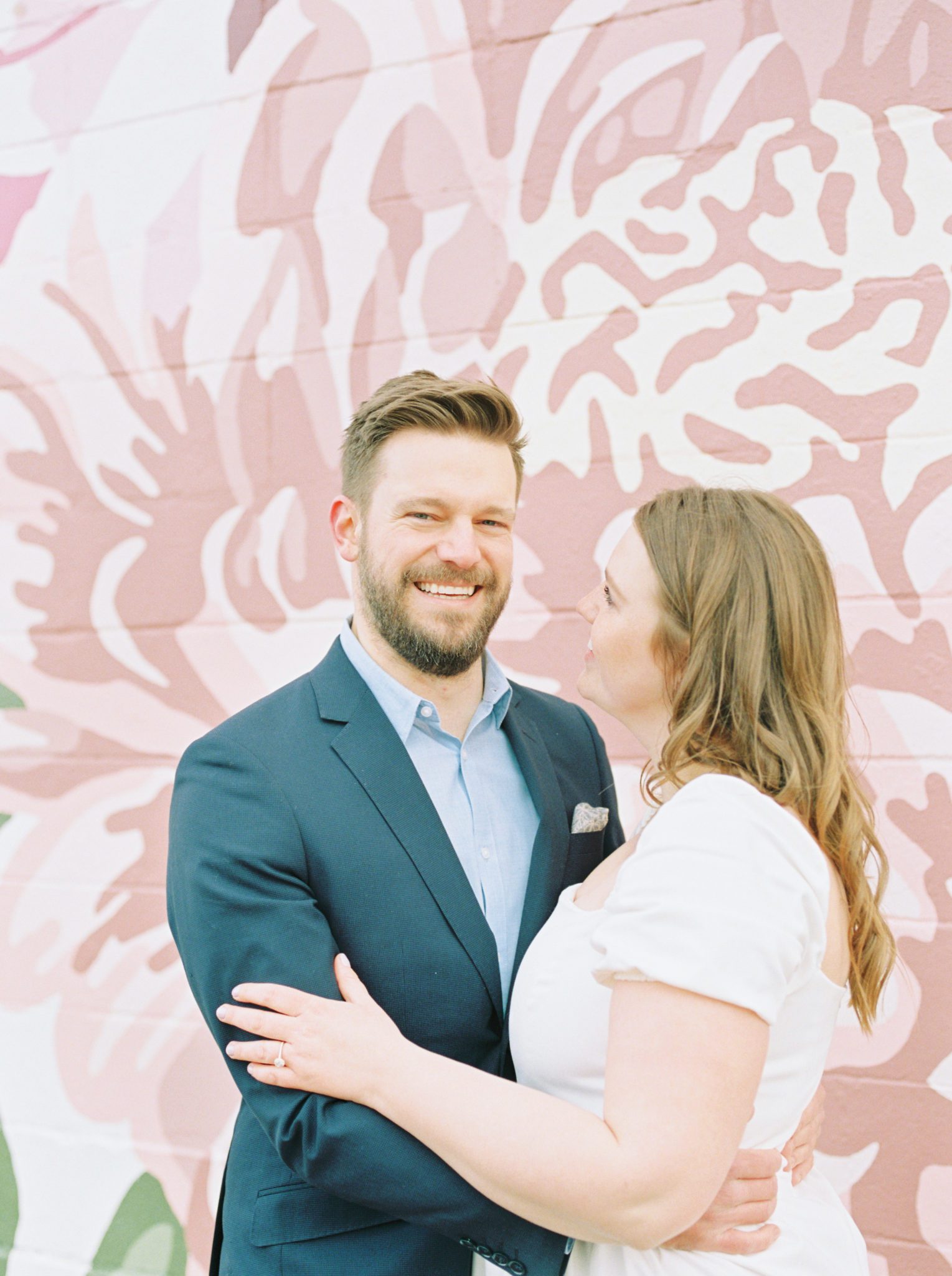 Stylish and romantic engagement photos in Edmonton Alberta with a pink floral wall