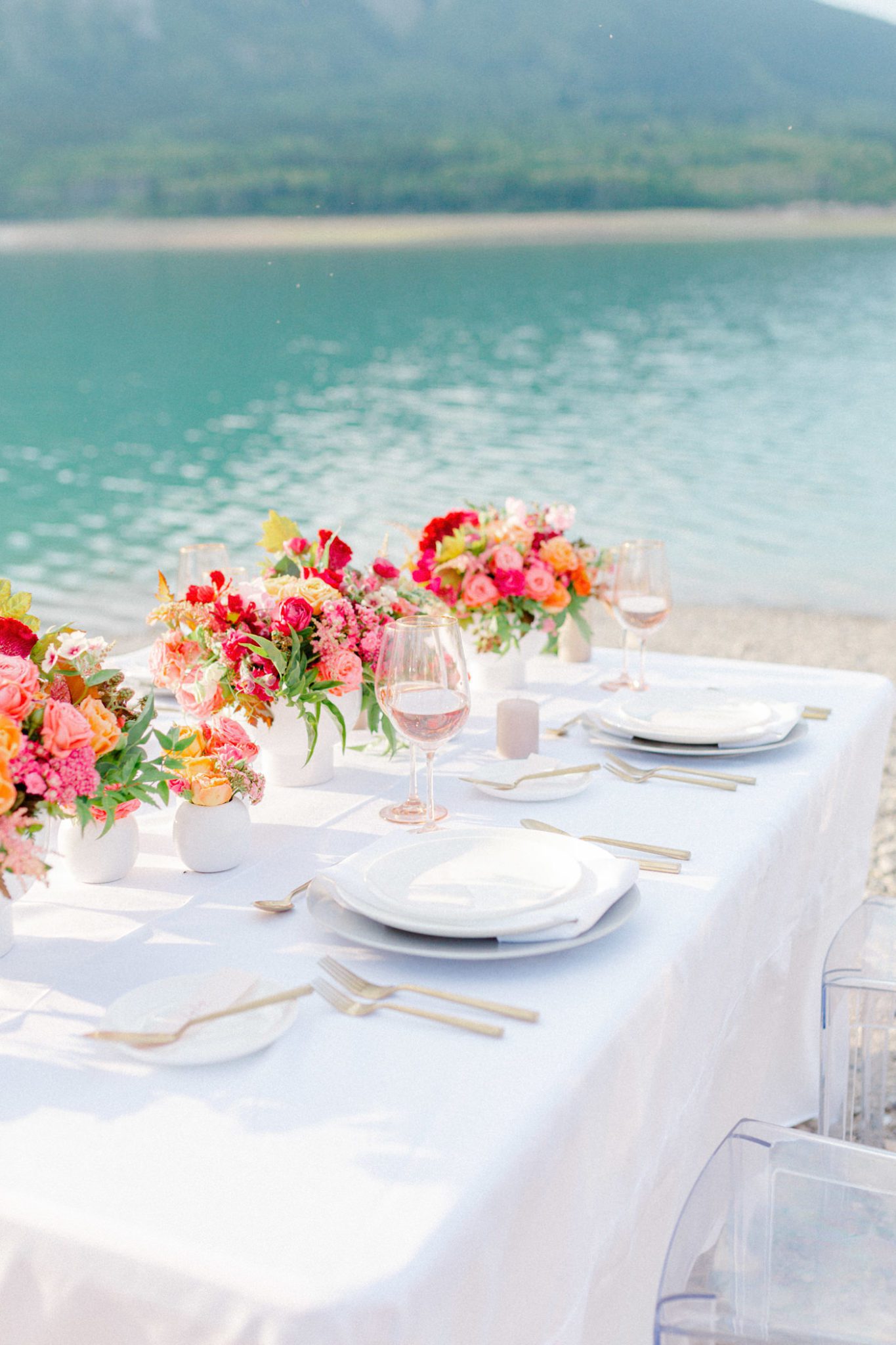 Dreamy lakeside wedding tablescape with vibrant summer flowers