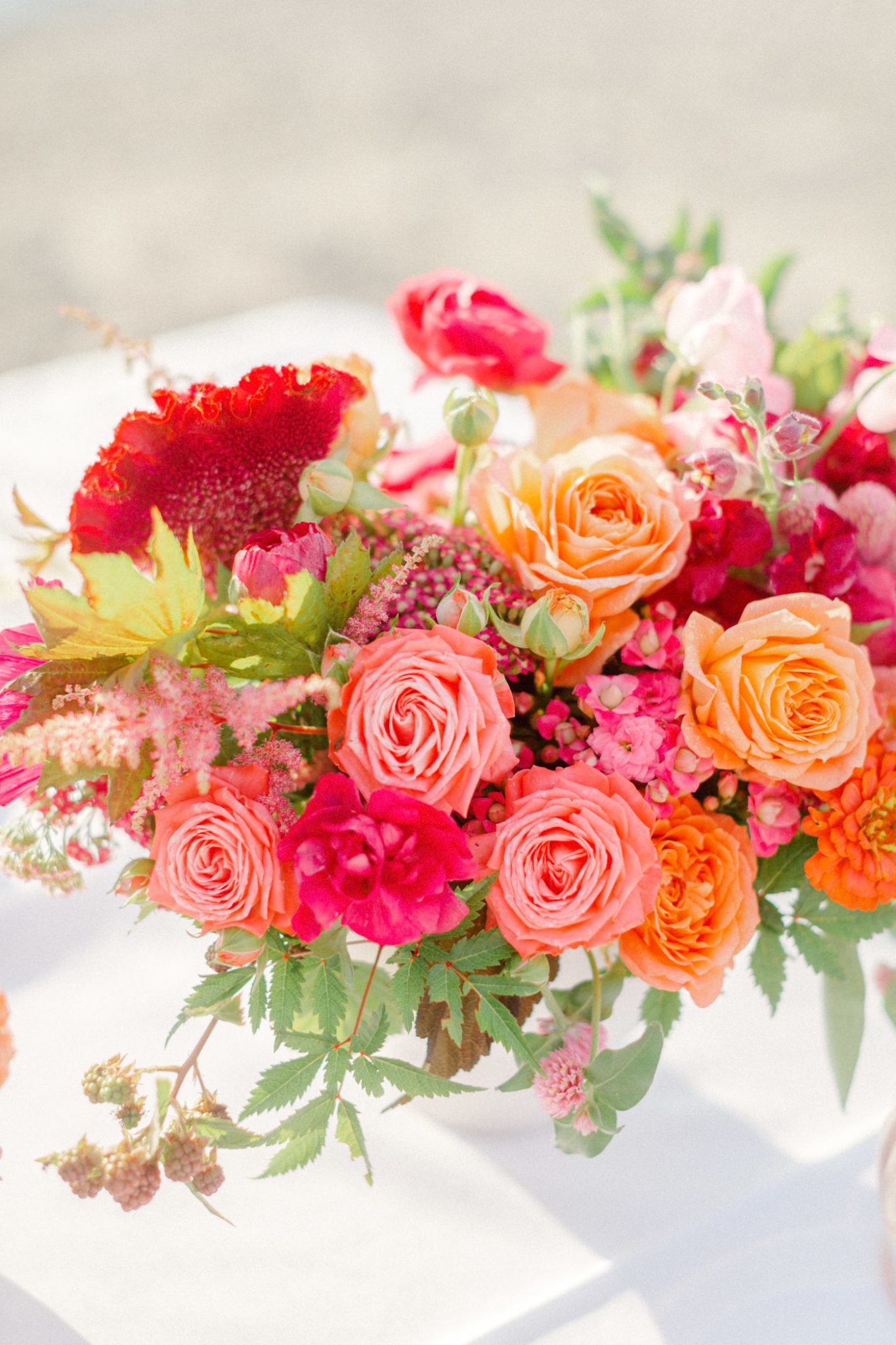 Wedding floral arrangement with pink, red, blush and orange florals