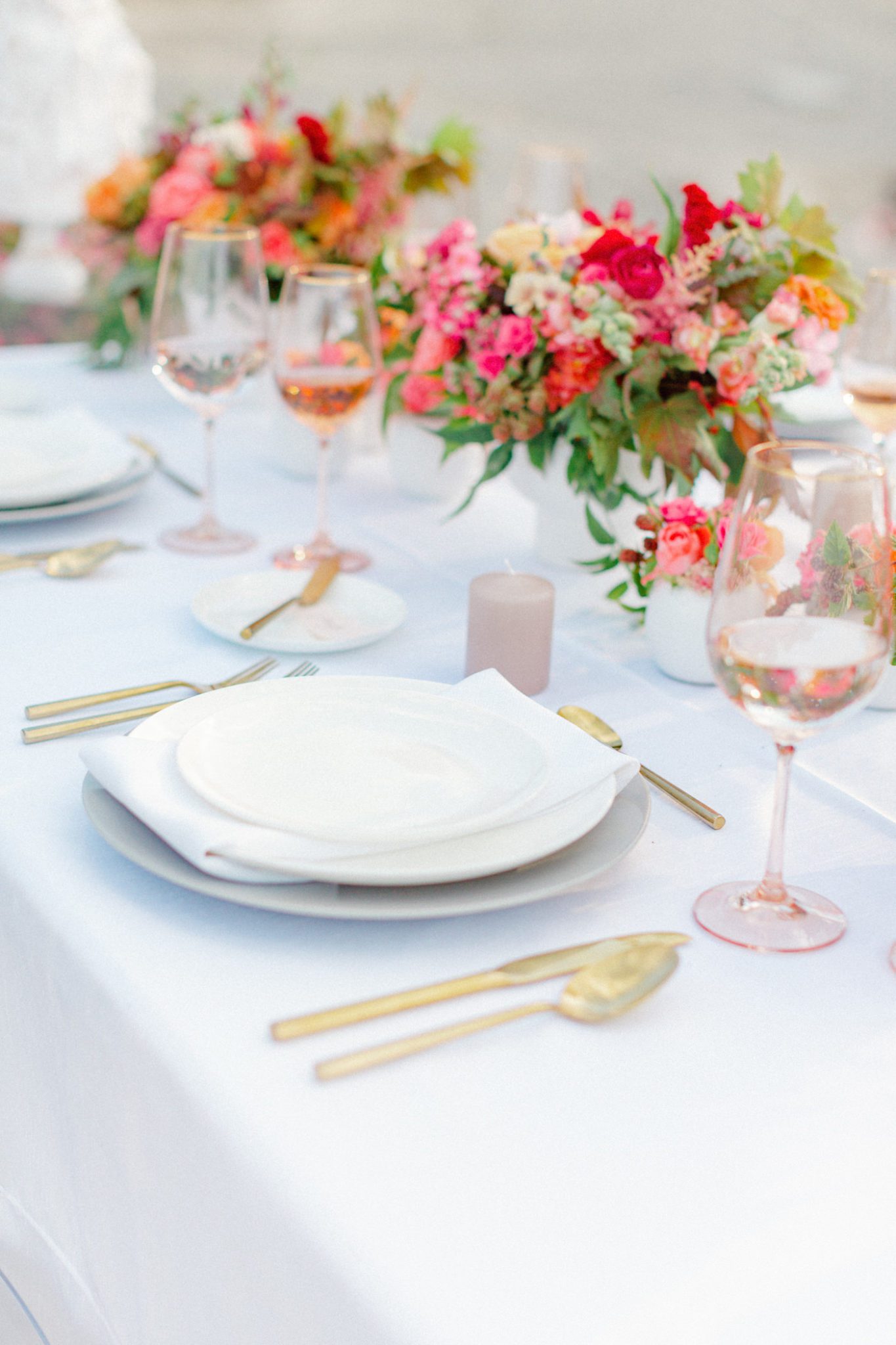 Summer lakeside tablescape inspiration with gold accents and vibrant florals