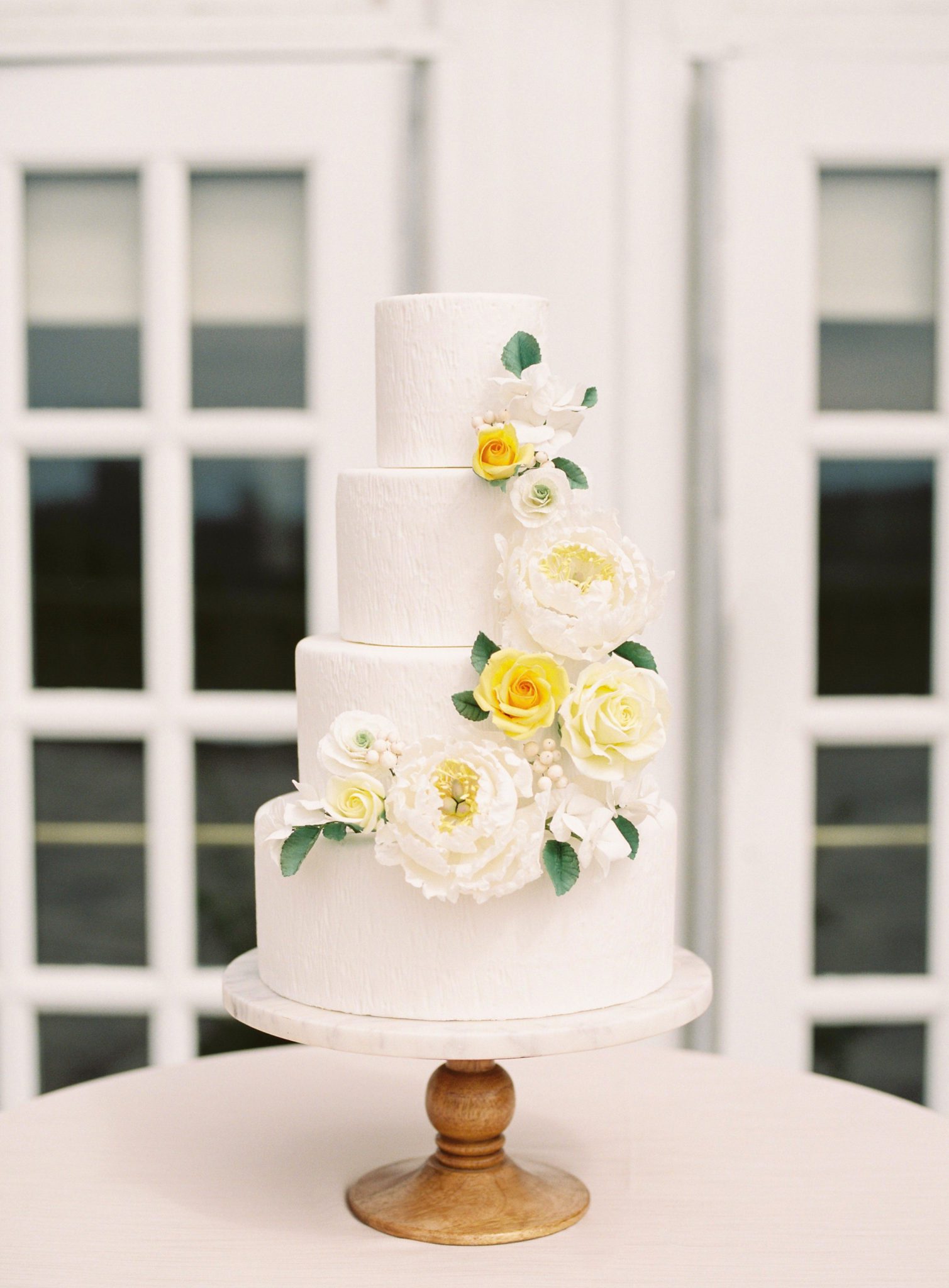 Three tiered yellow and white cake with floral inspiration for your wedding cake