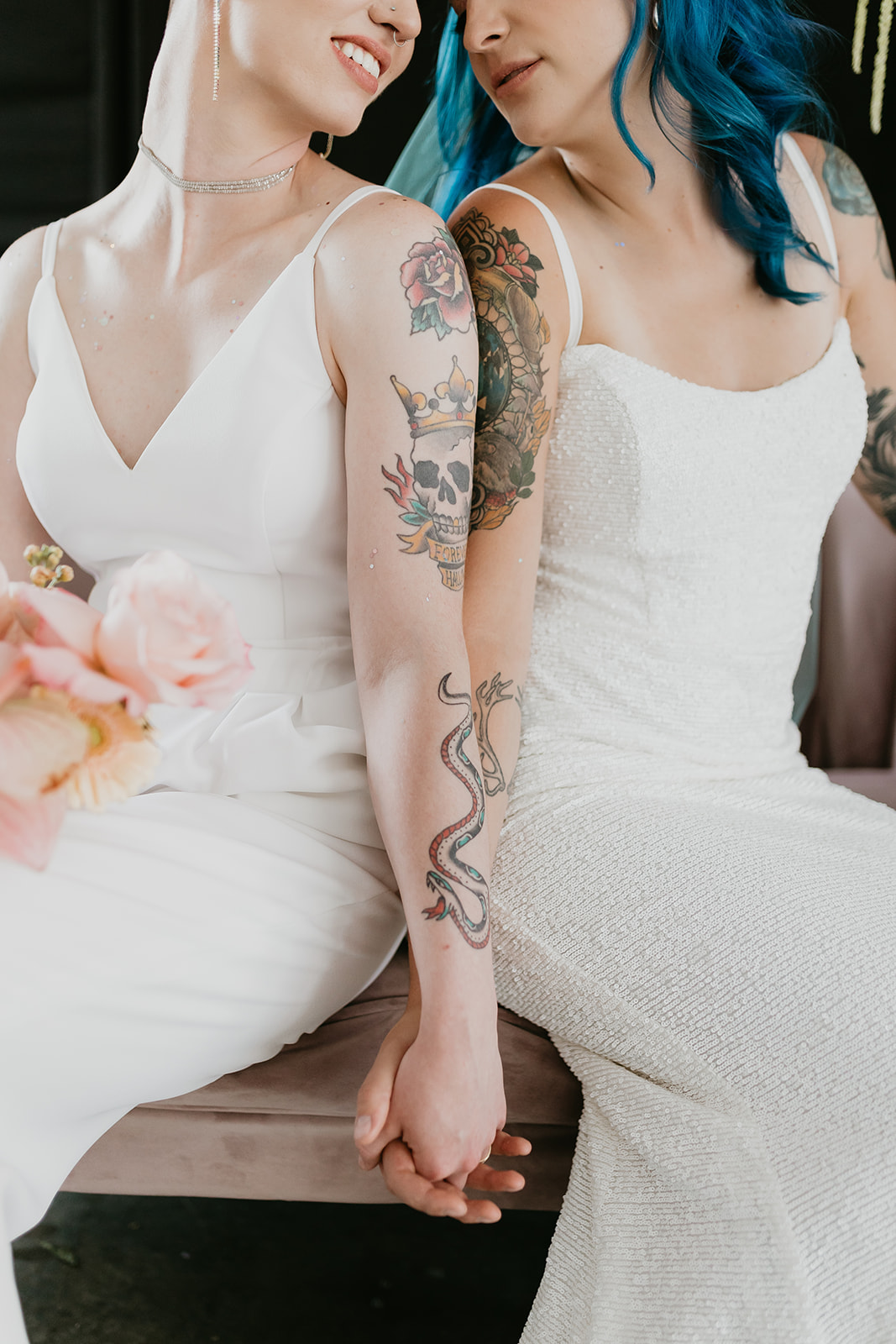 Tattooed brides hold hands