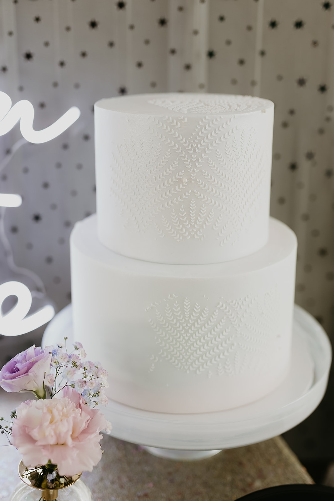 Delicately detailed white two-tiered wedding cake