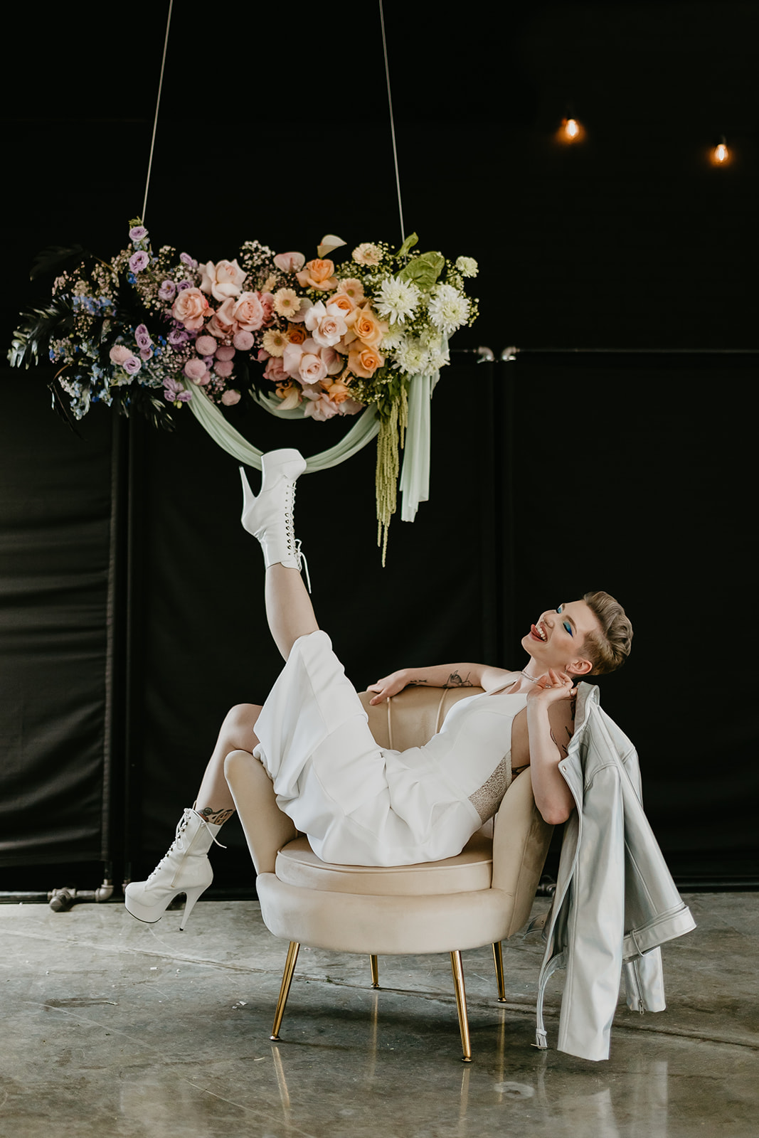 Rocker chic bride poses in an armchair