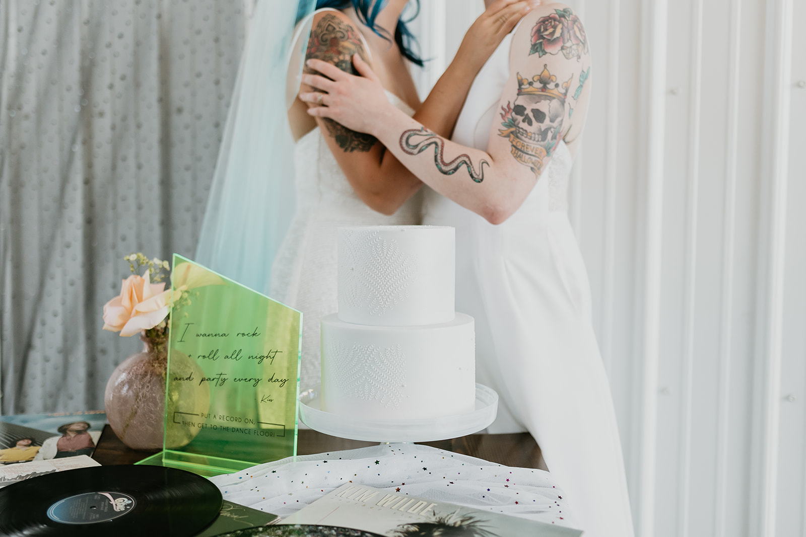 Tattoo brides pose with their wedding cake