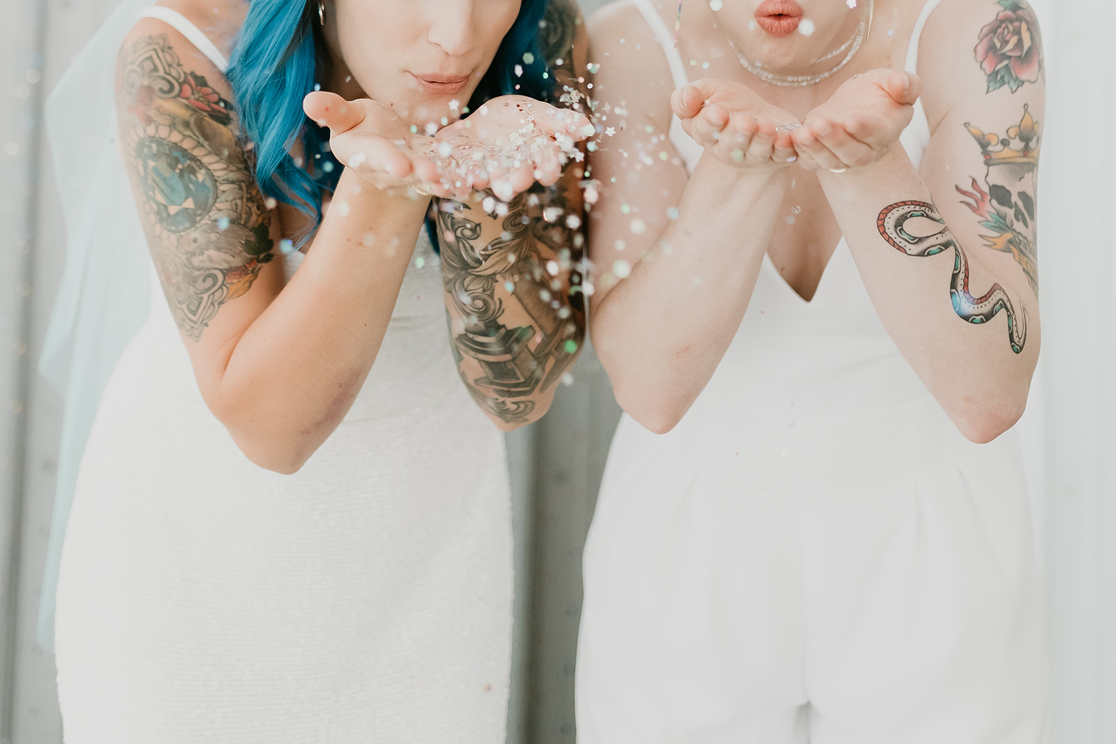 Brides blow glitter towards the camera at Alberta wedding venue 52 North Venue