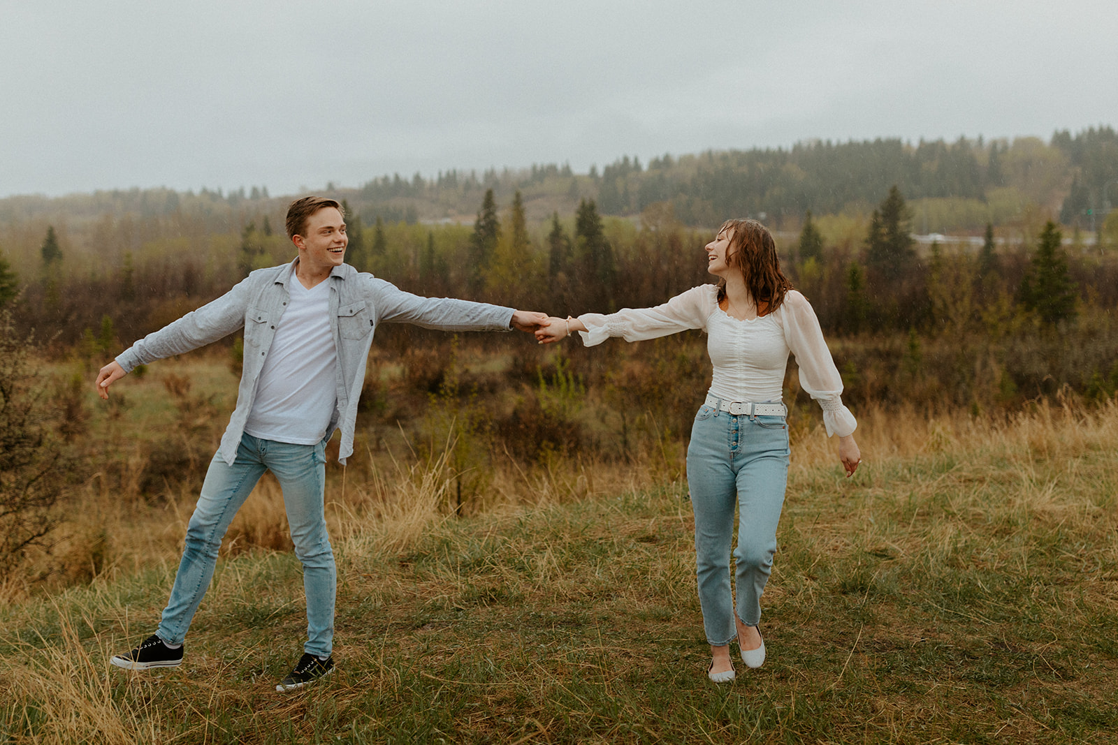 Newly engaged couple play around in the rain during this impossibly cute rainy day session