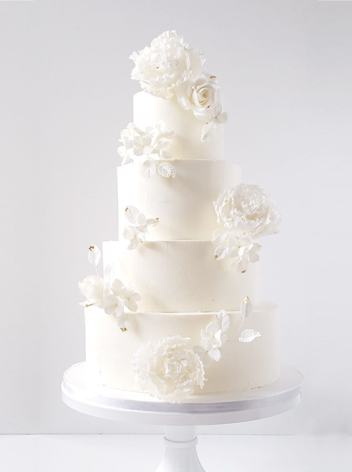 Stunningly delicate monochromatic  show-stopping wedding cake white wedding cake with impossibly romantic handmade sugar flowers