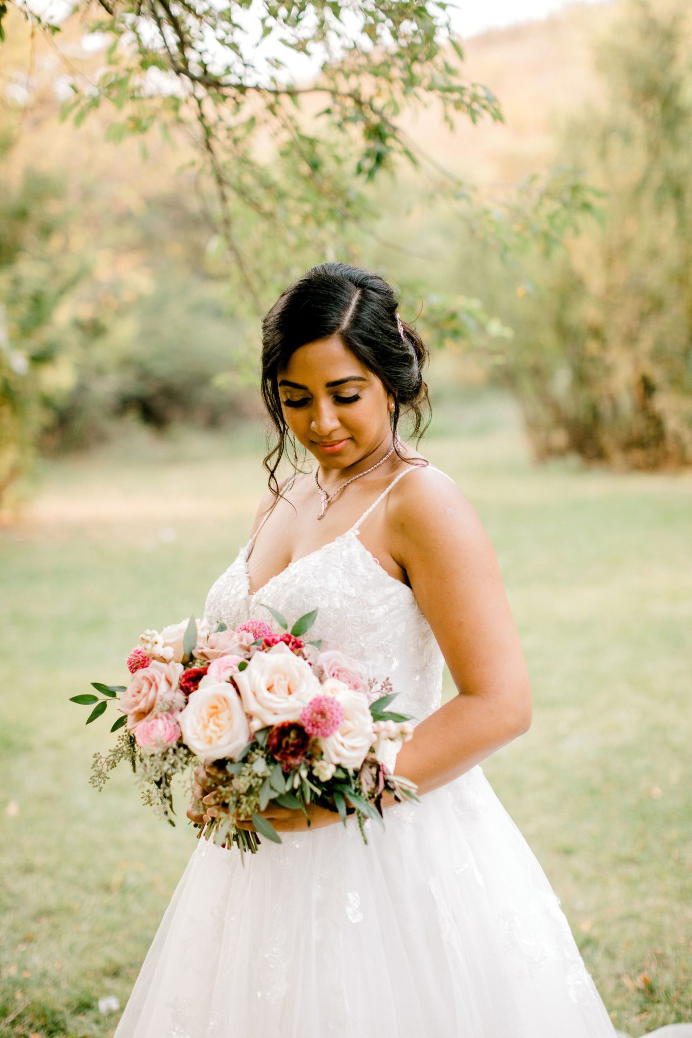 Stunning bride poses underneath romantic tree branches in a Calgary park