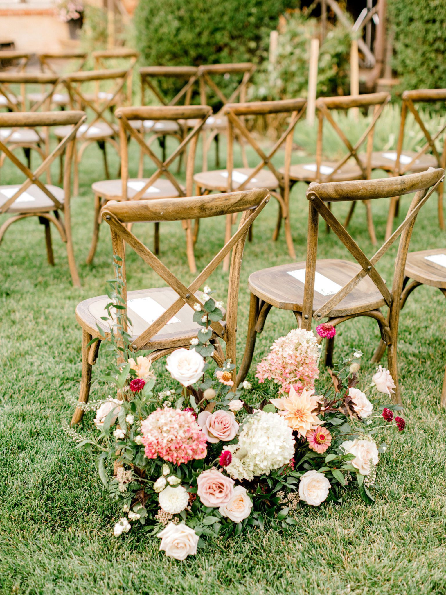 Outdoor summer wedding ceremony inspiration with farm style chairs and lavish floral details at Bow Valley Ranche near Calgary Alberta