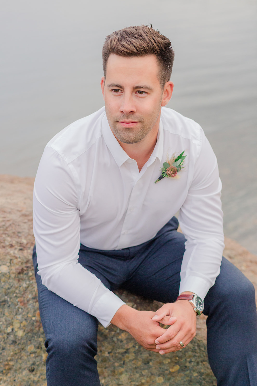 Casually styled groom in a white dress shirt and navy pants for this lakeside elopement inspiration