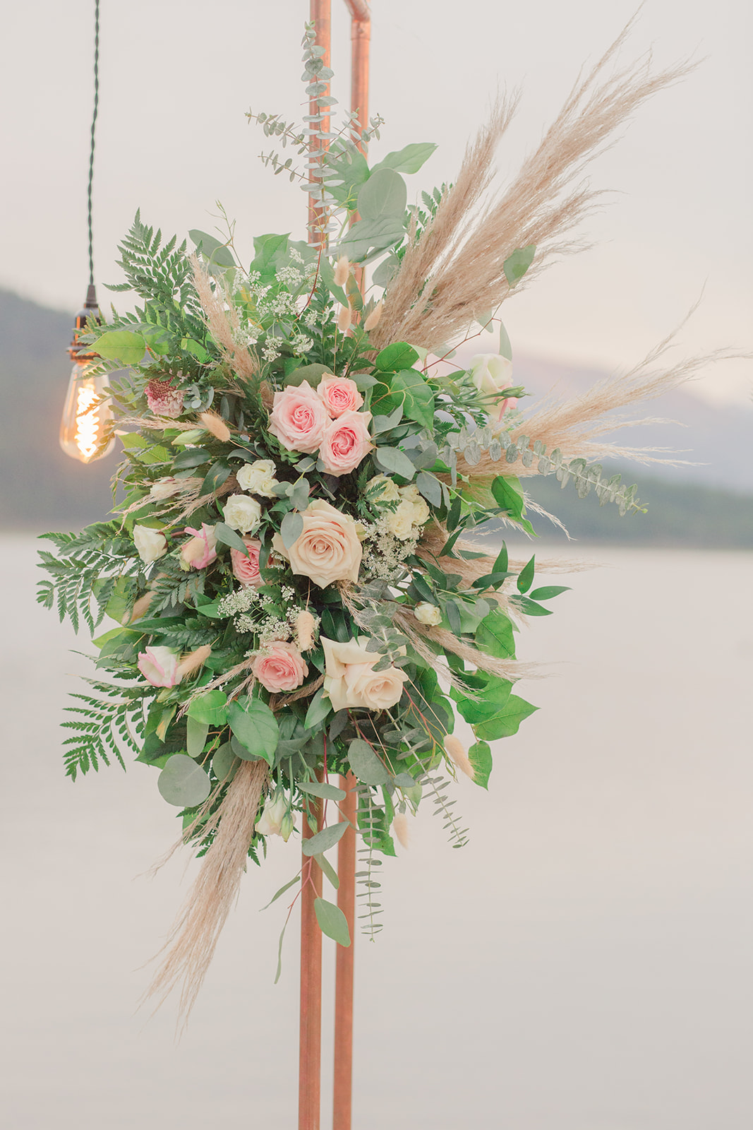 Blush blooms and florals for intimate wedding decor featuring industrial lights