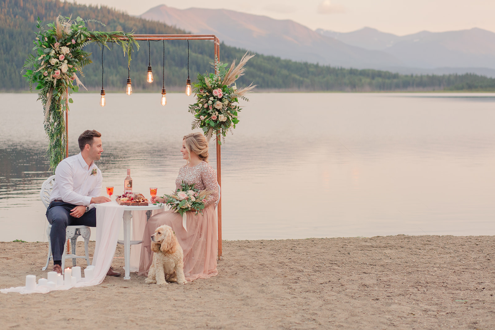 Romantic floral arch with industrial lights for a lakeside elopement in Grand Cache Alberta