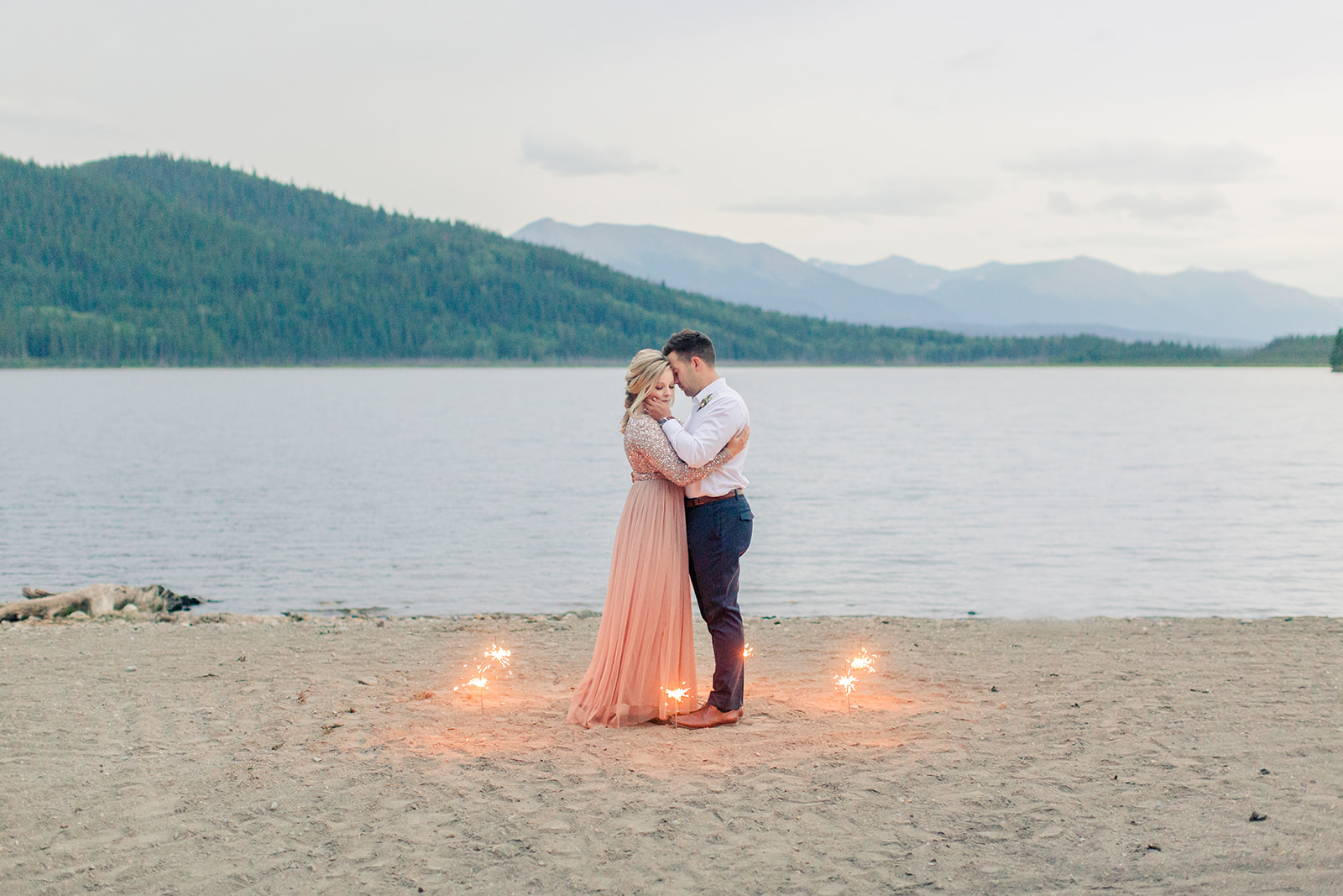 Sparklers for a lakeside elopement on the sandy beach of Grand Cache Lake
