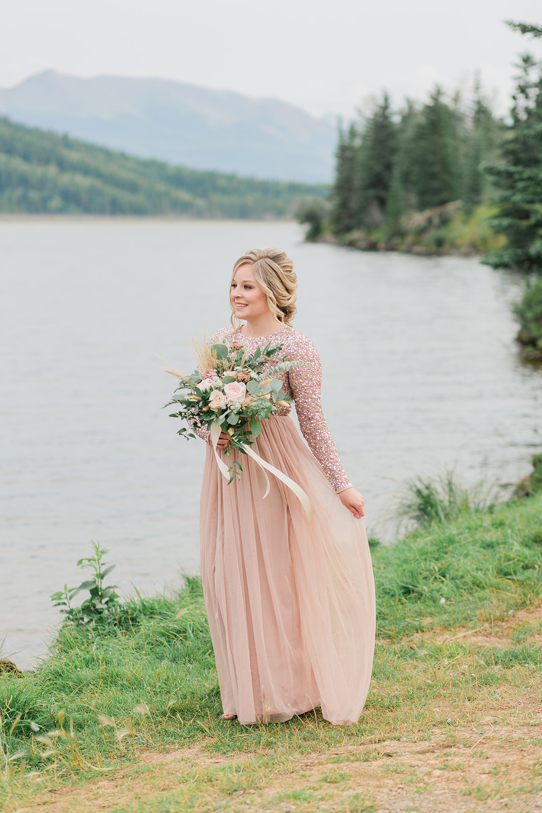Lakeside blushing bride in a sparkling blush gown with mountain views in the background