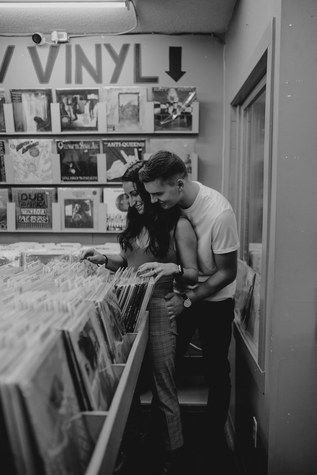 Couple browses through records for their record store engagement session