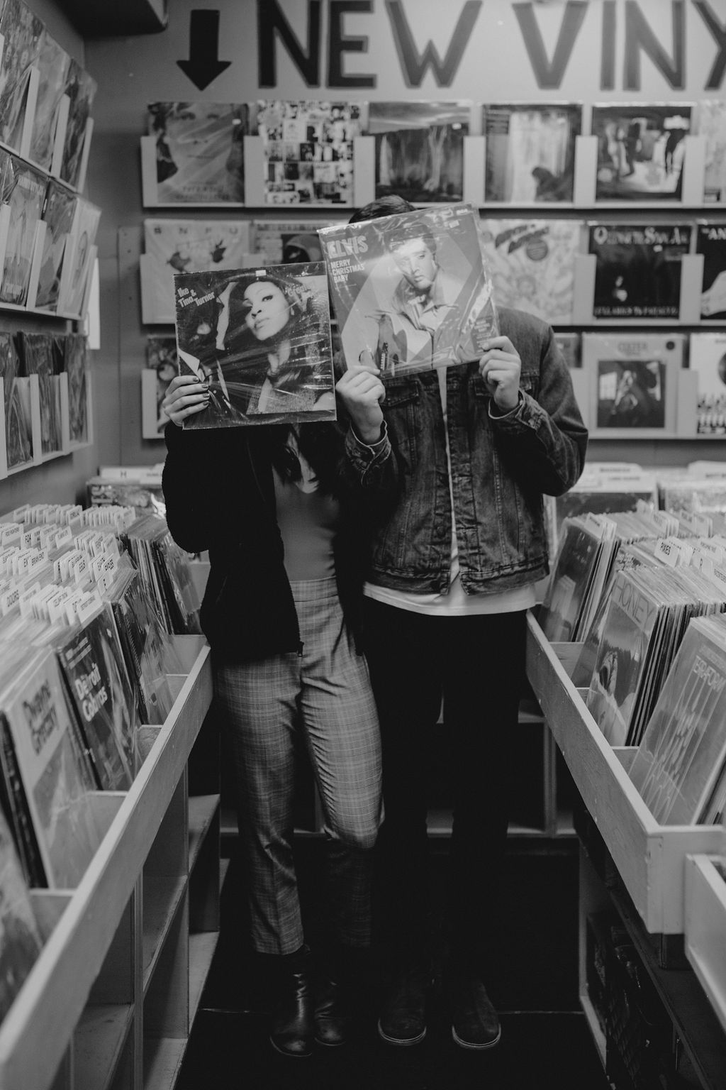 Black and white portrait of couple posing with records