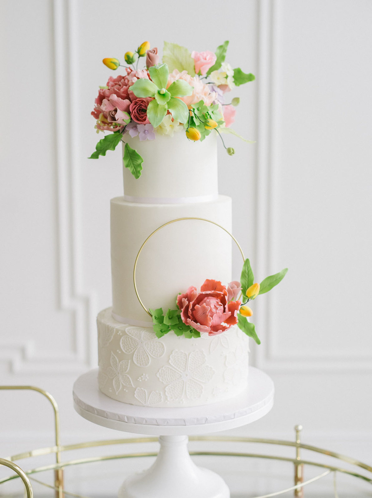 Monochromatic white wedding cake with colourful sugar flowers