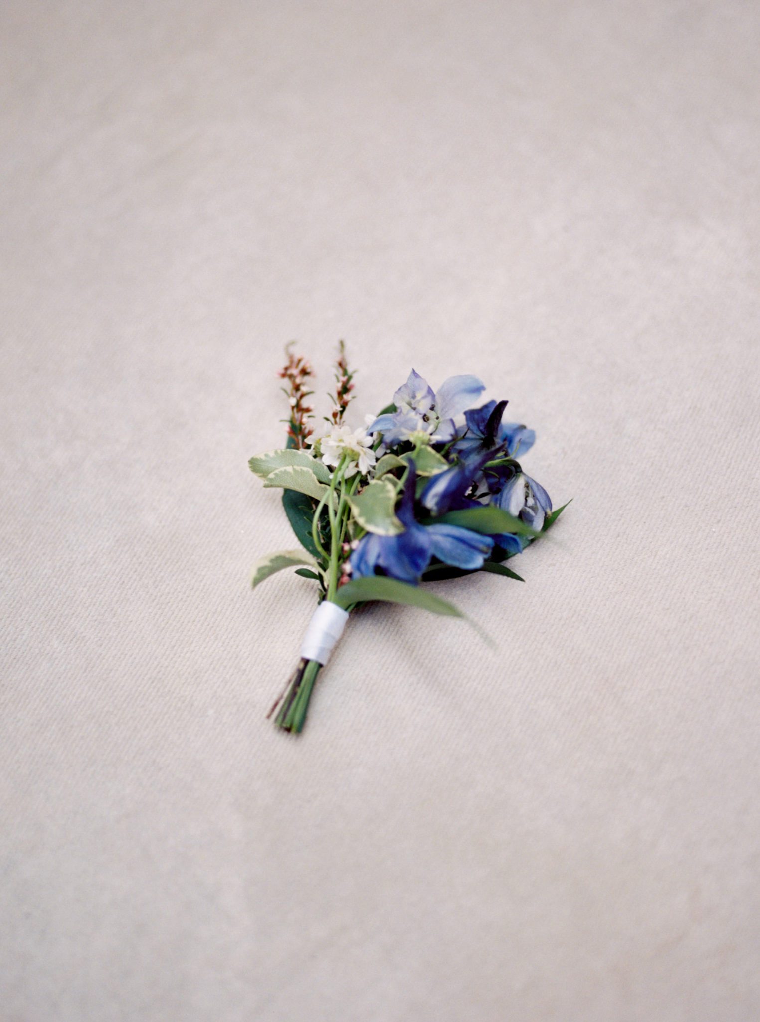 Blue mountain inspired boutonnière with greenery