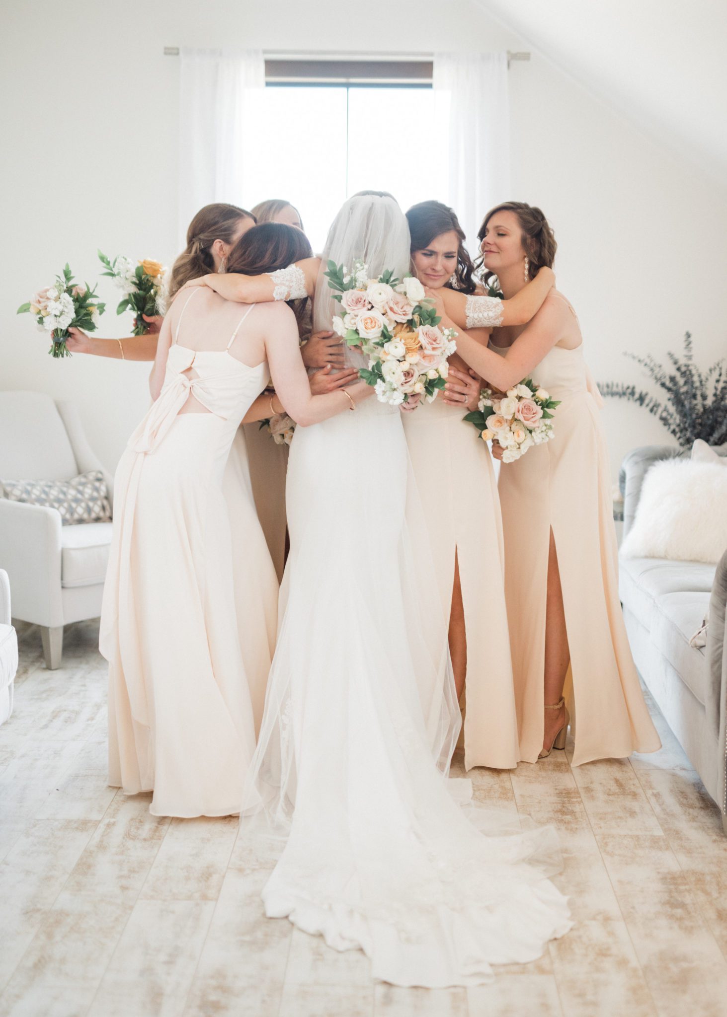 Bride and bridesmaids share a hug 